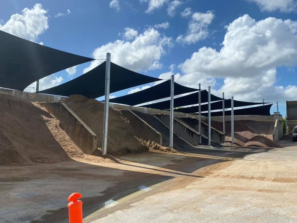 Sand and Gravel Piles Under Black Shade Sails — Professional Shade Sail Installation in Caloundra, QLD