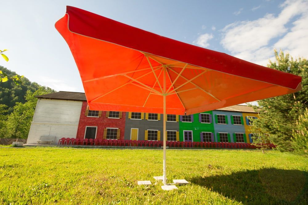 Orange Parasol in Front of a Colorful Building — Professional Shade Sail Installation in Noosa, QLD