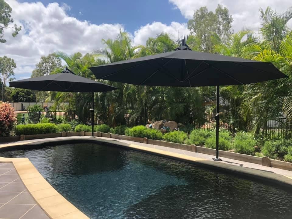 Elegant Pool Area with Elegant Umbrellas — Professional Shade Sail Installation in Ayr, QLD