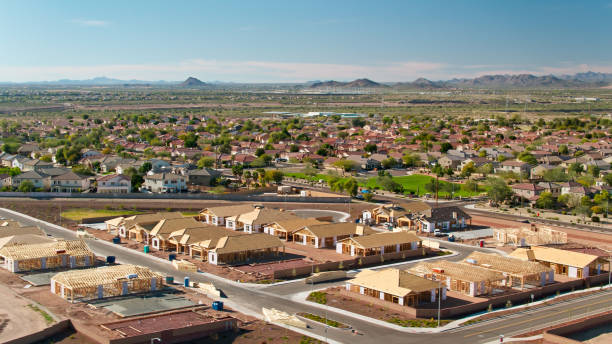 An aerial view of a residential area under construction with mountains in the background.