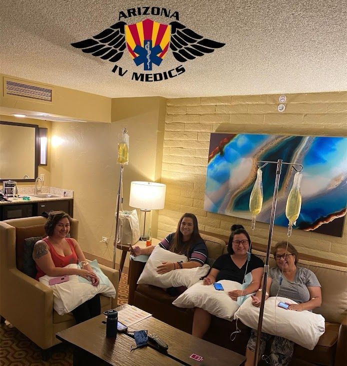 A group of women are sitting in a living room with a logo for arizona iv medics on the ceiling