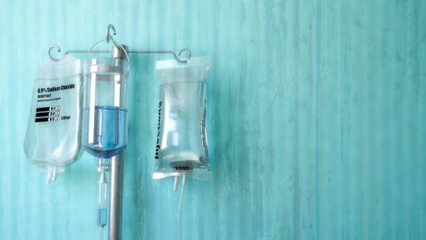 A close up of an iv pole with bags of liquid hanging from it.