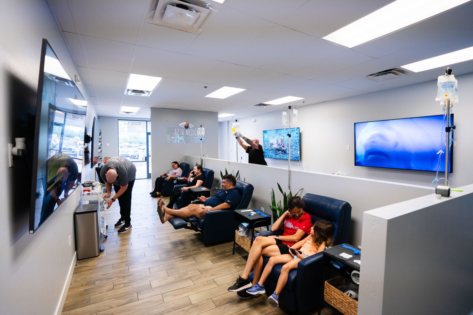 A group of people are sitting in chairs in a waiting room.