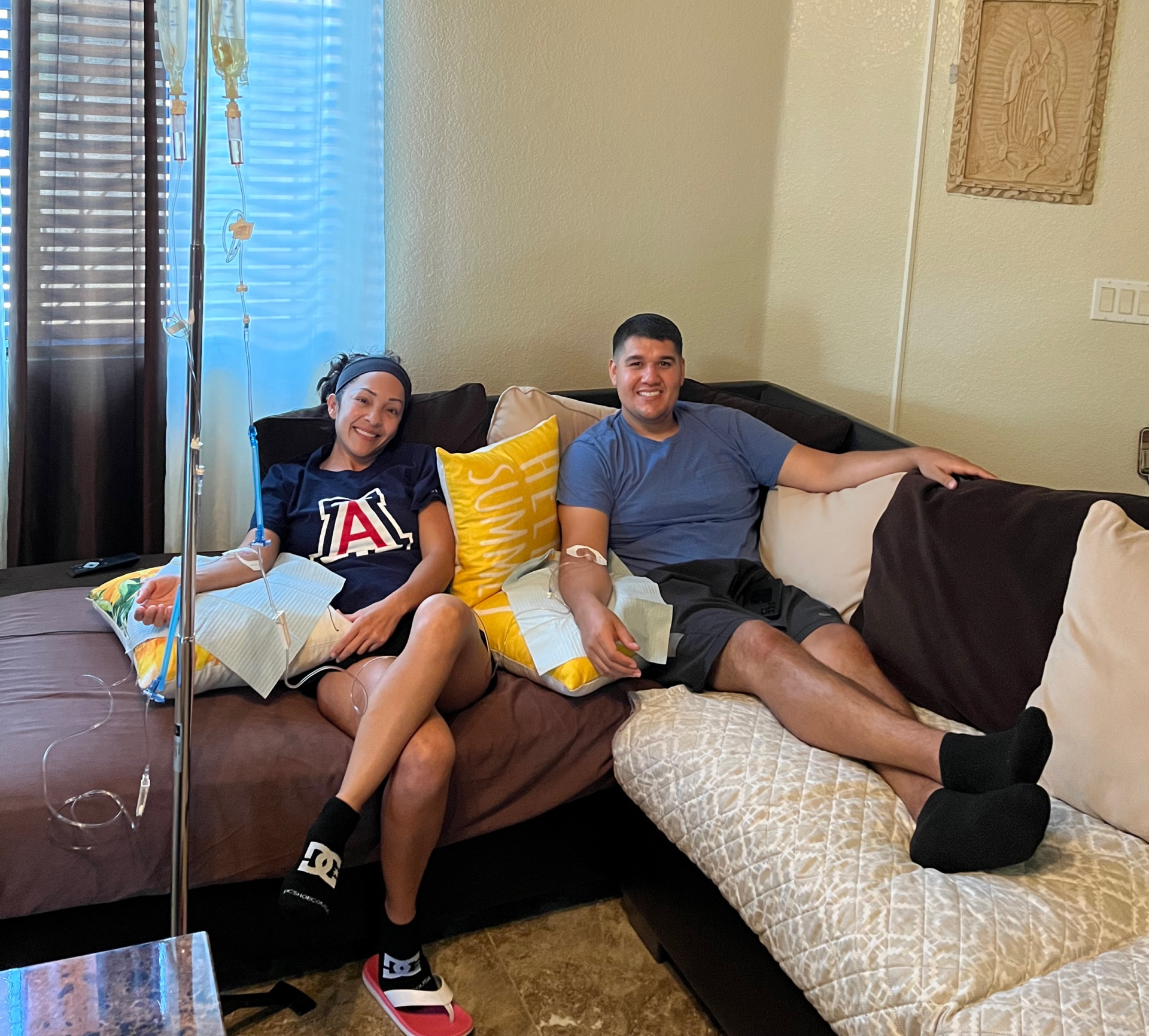 A man and a woman are sitting on a couch in a living room.