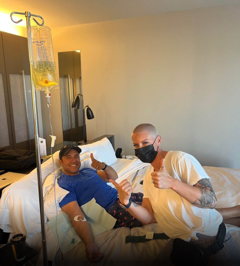 A man in a hospital bed giving a thumbs up