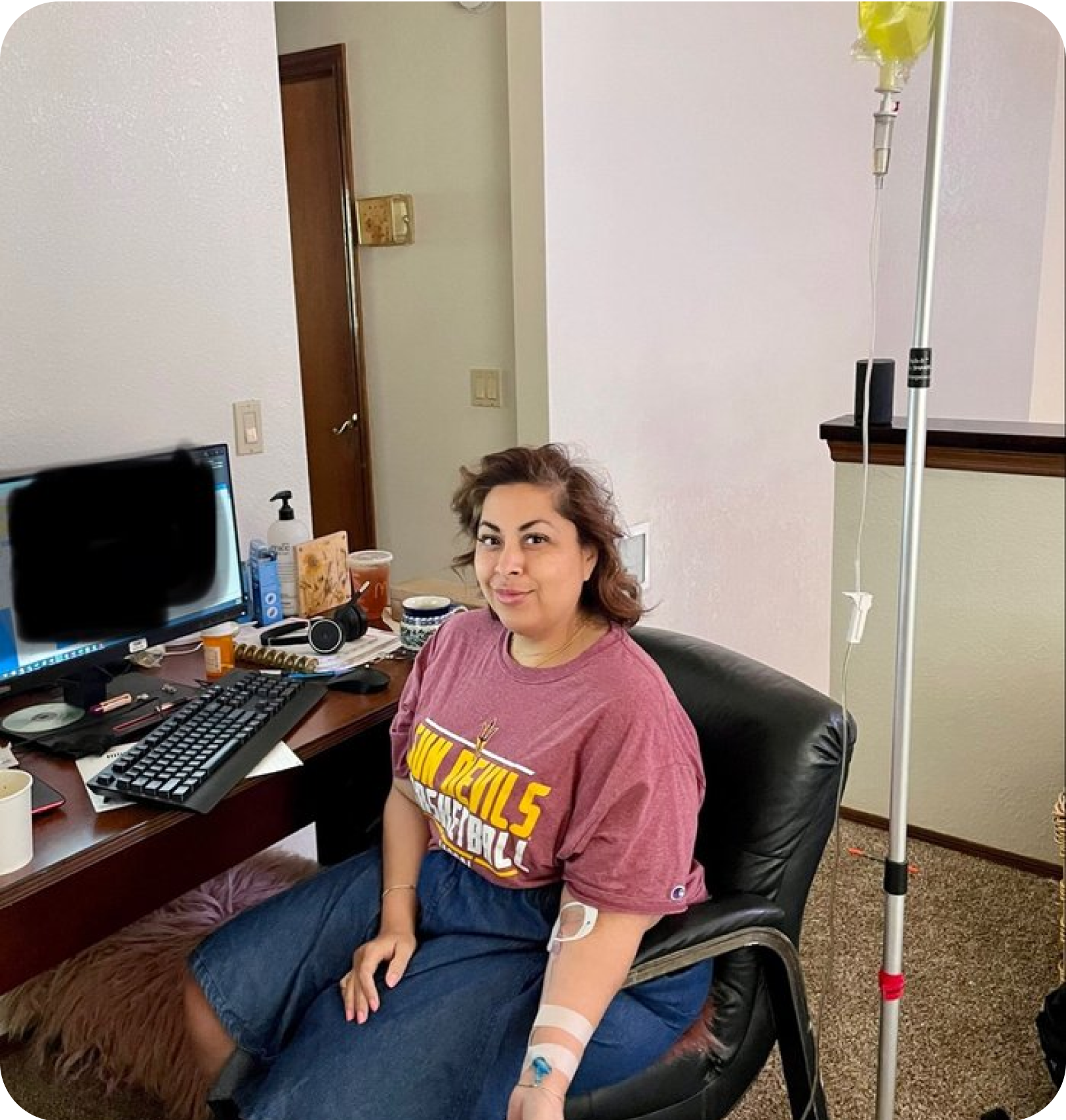 A woman is sitting in a chair with an iv in her hand