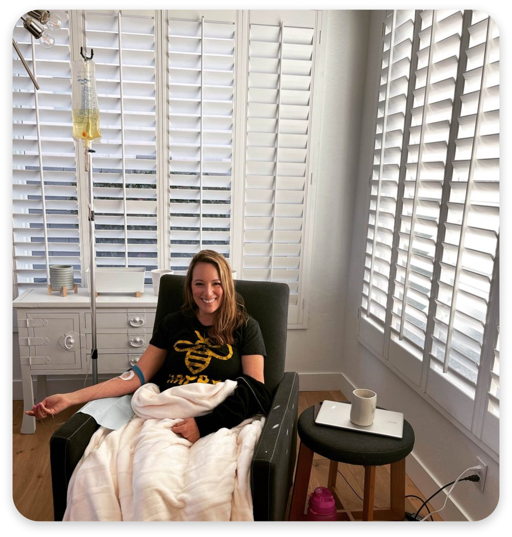 A woman is sitting in a chair with an iv in her arm.