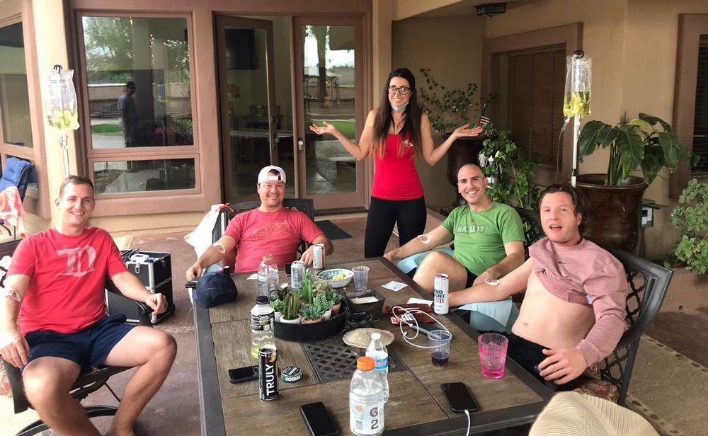 A group of people are sitting around a table on a patio.
