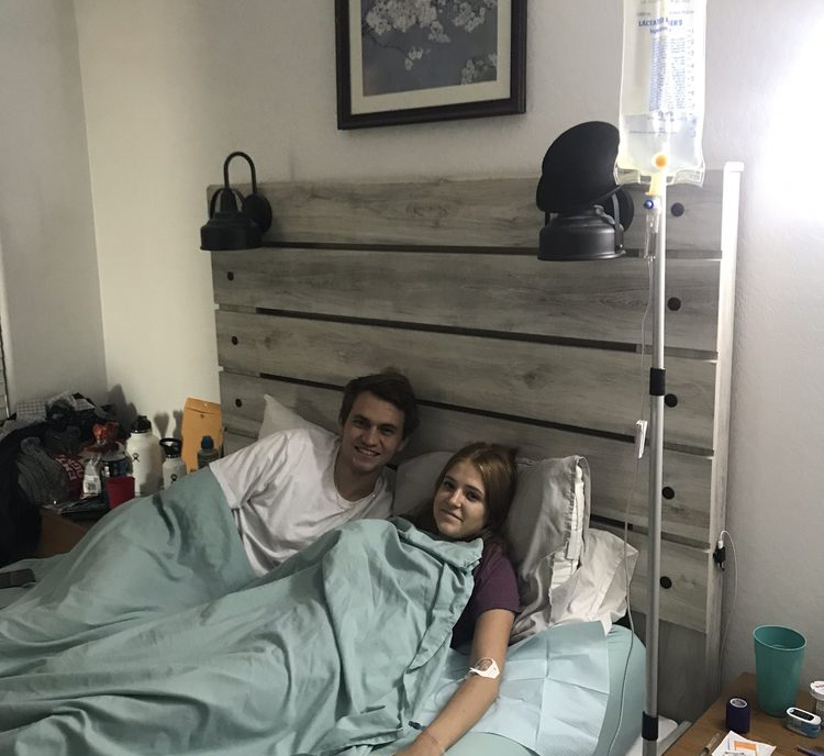 A man and a woman are laying in a hospital bed