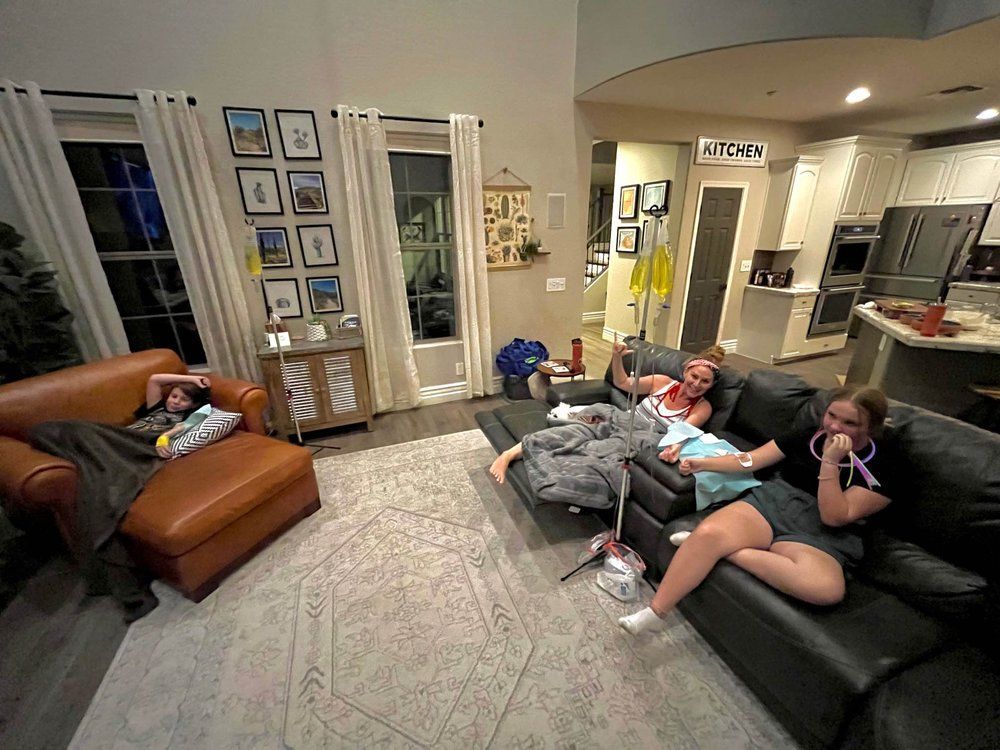 A group of people are sitting on a couch in a living room.