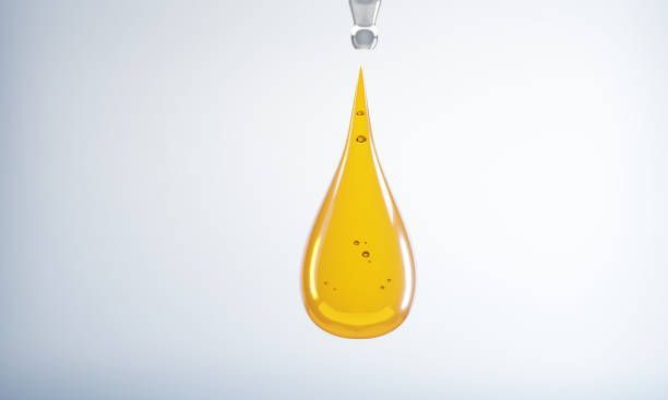 A drop of yellow liquid is being poured from a pipette.