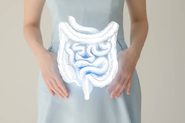 A woman is holding her stomach with a drawing of her intestines.