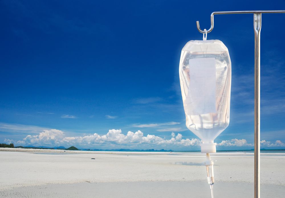 An iv bag is hanging from a pole on a beach.