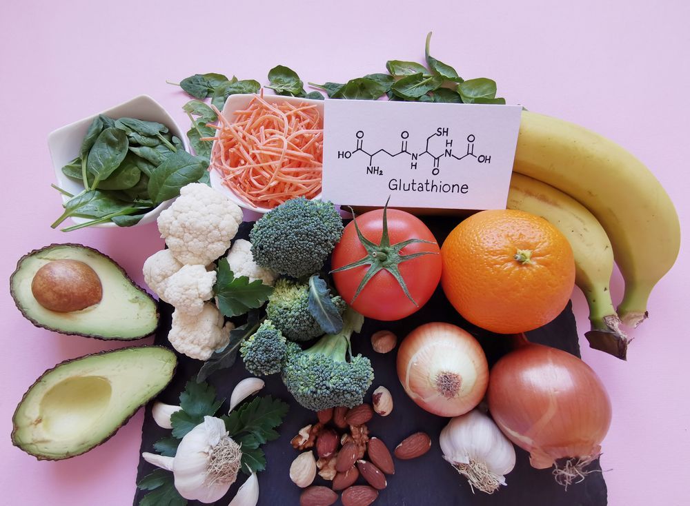 A variety of fruits and vegetables with a sign that says glutathione