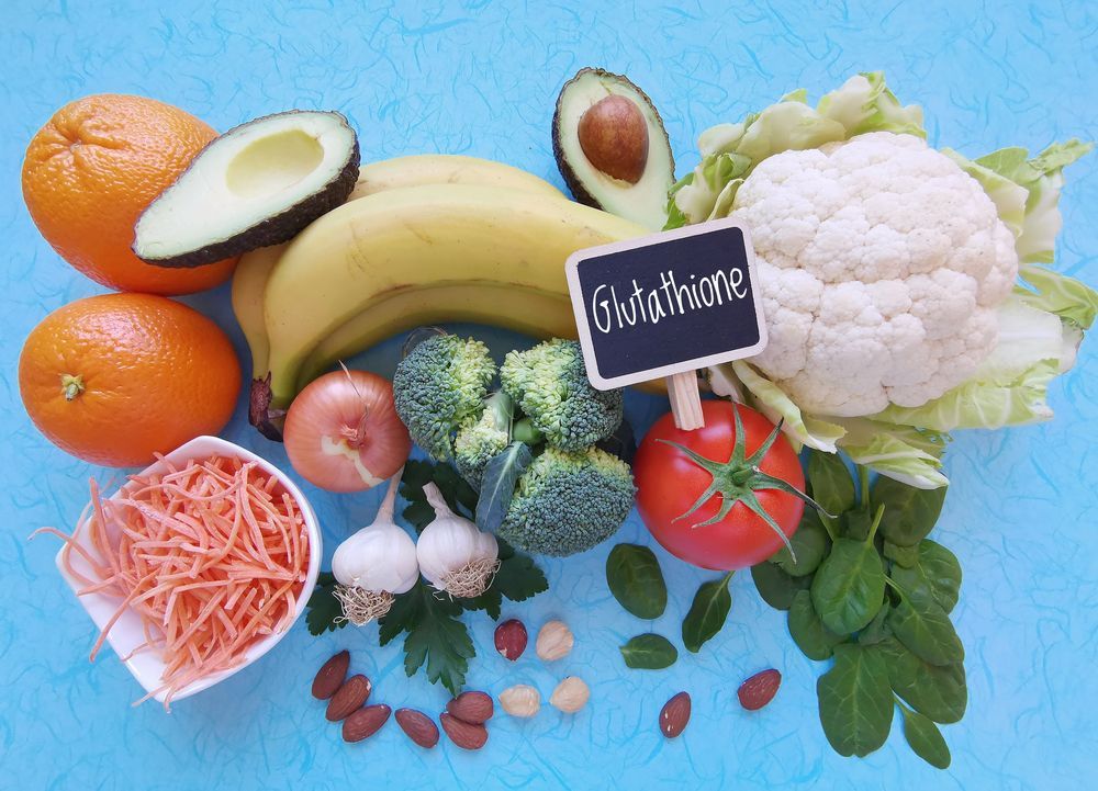 A variety of fruits and vegetables with a sign that says glutathione