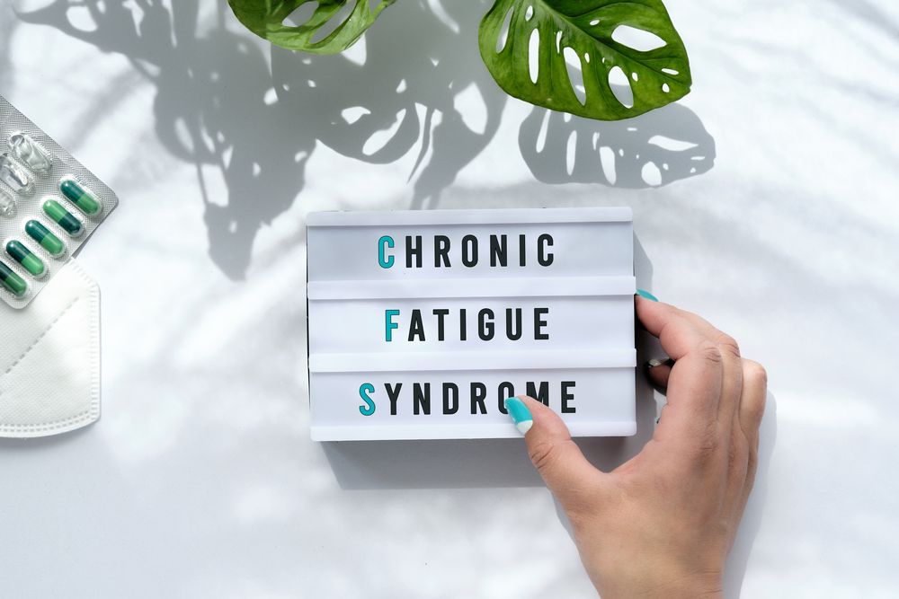 A person is holding a sign that says `` chronic fatigue syndrome ''.