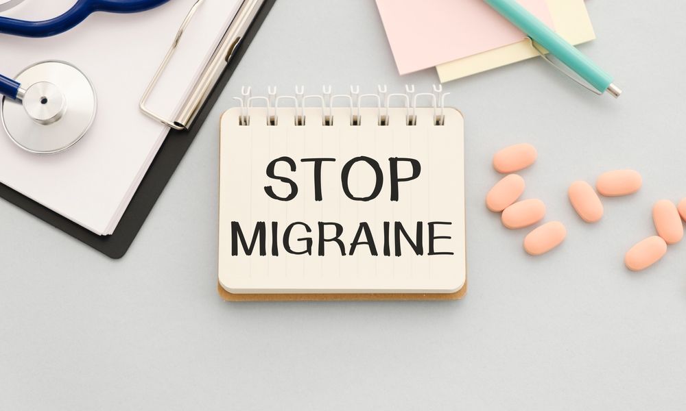 A notebook with the words `` stop migraine '' written on it.