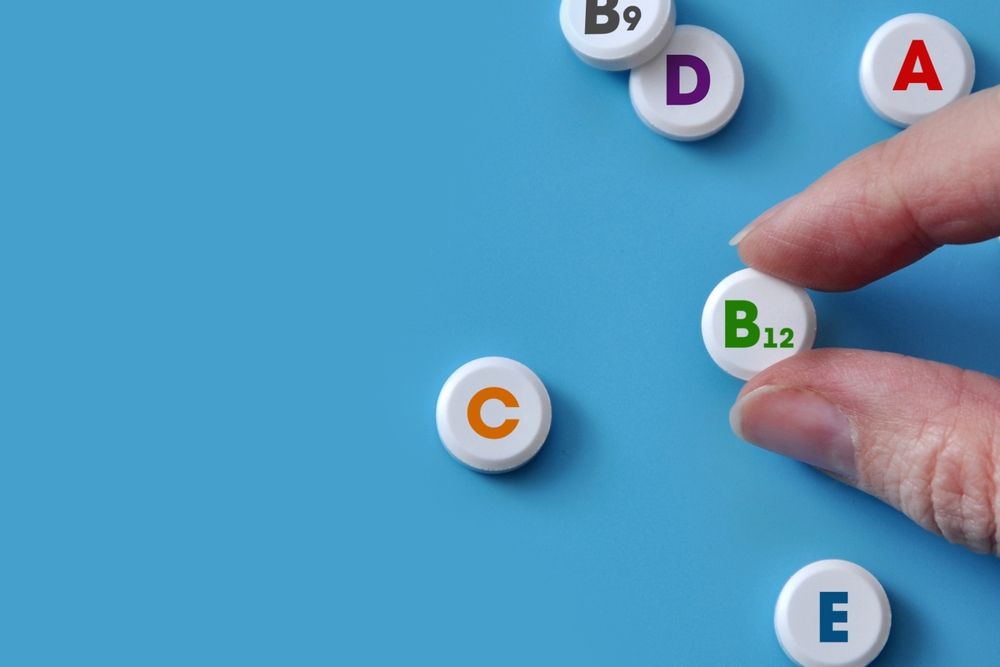 A person is holding a pill with the letter b on it.