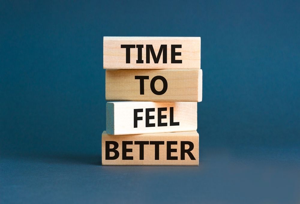 A stack of wooden blocks with the words time to feel better written on them.