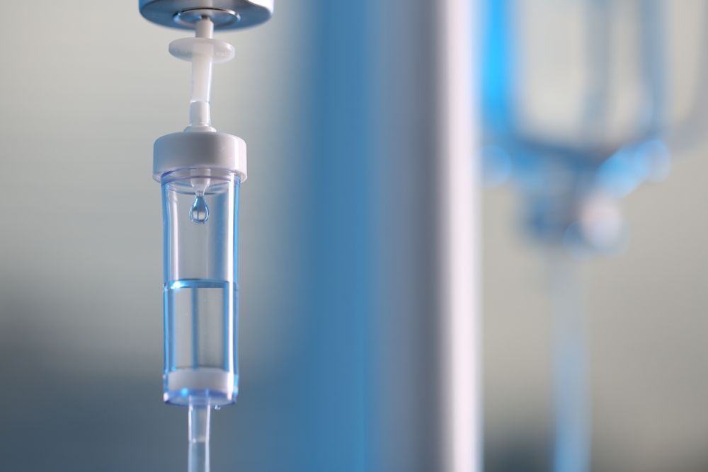 A close up of an intravenous drip in a hospital room.