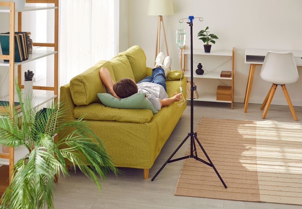 A man is laying on a yellow couch in a living room.