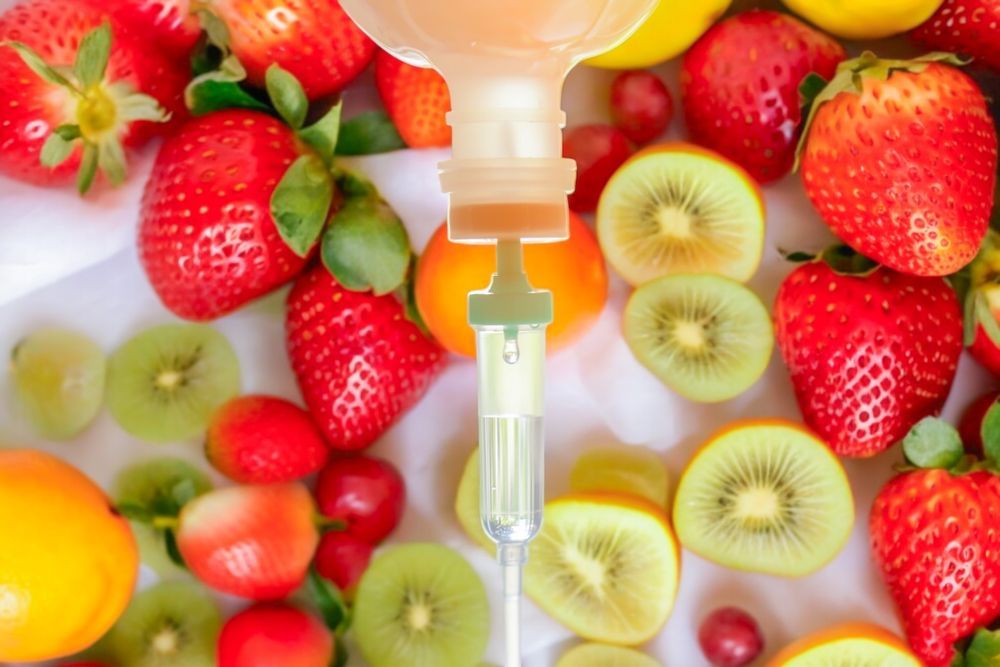 A syringe is sitting on top of a pile of fruit.