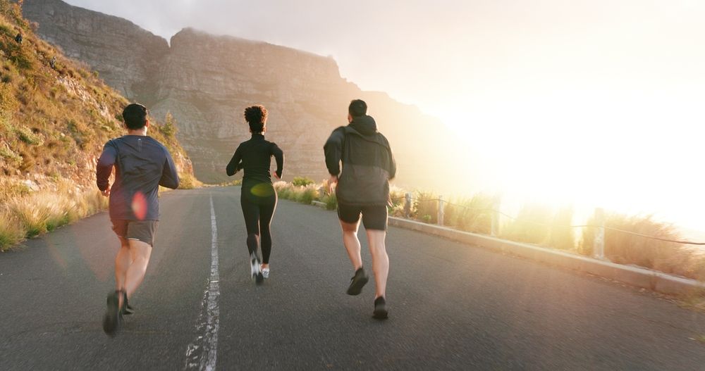 A group of people are running down a road.