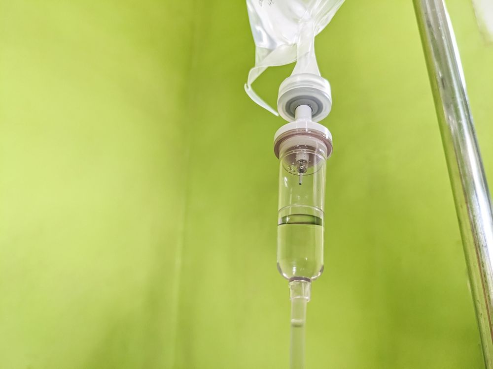 A close up of an iv drip in a hospital room.