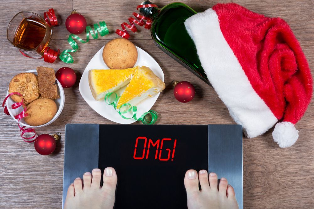 A person is standing on a scale with a santa hat and christmas decorations around them.