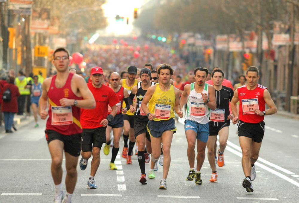 A group of men are running a marathon on a city street