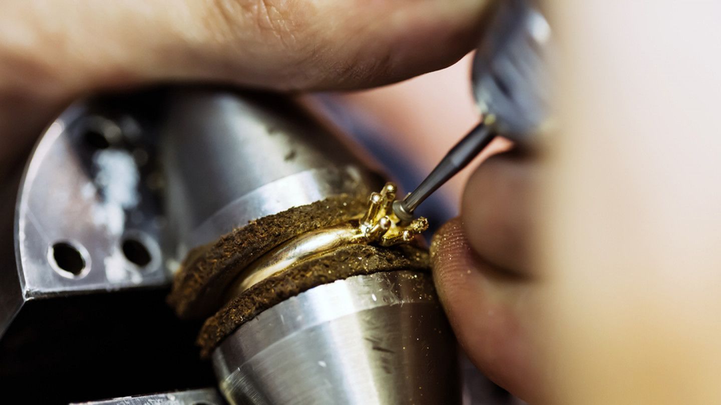 A close up of a person making a ring with a machine.