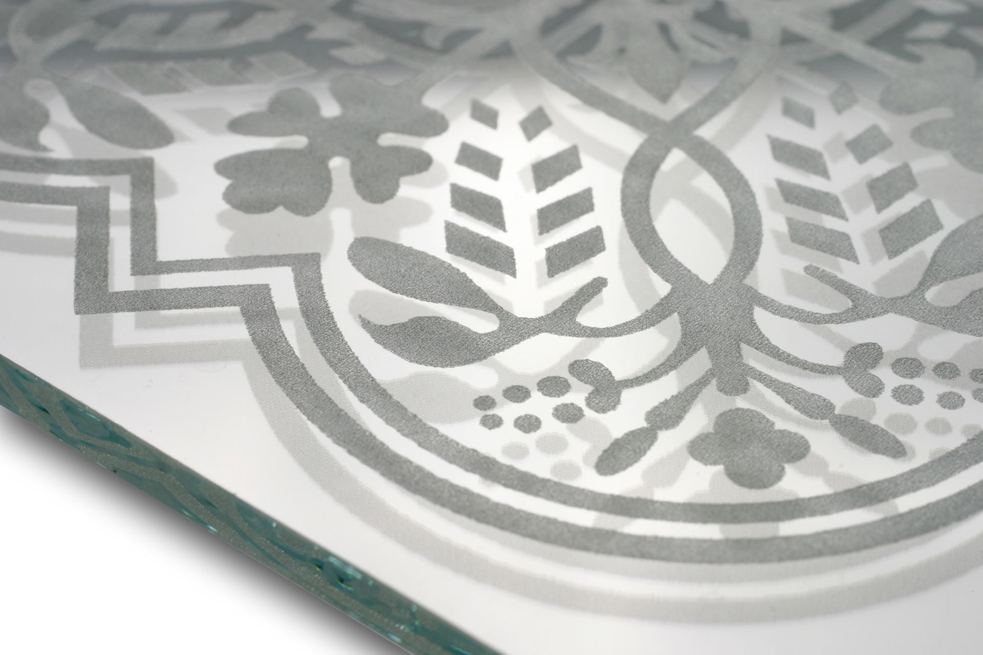 Close-up of a frosted glass panel with gray geometric and leaf patterns