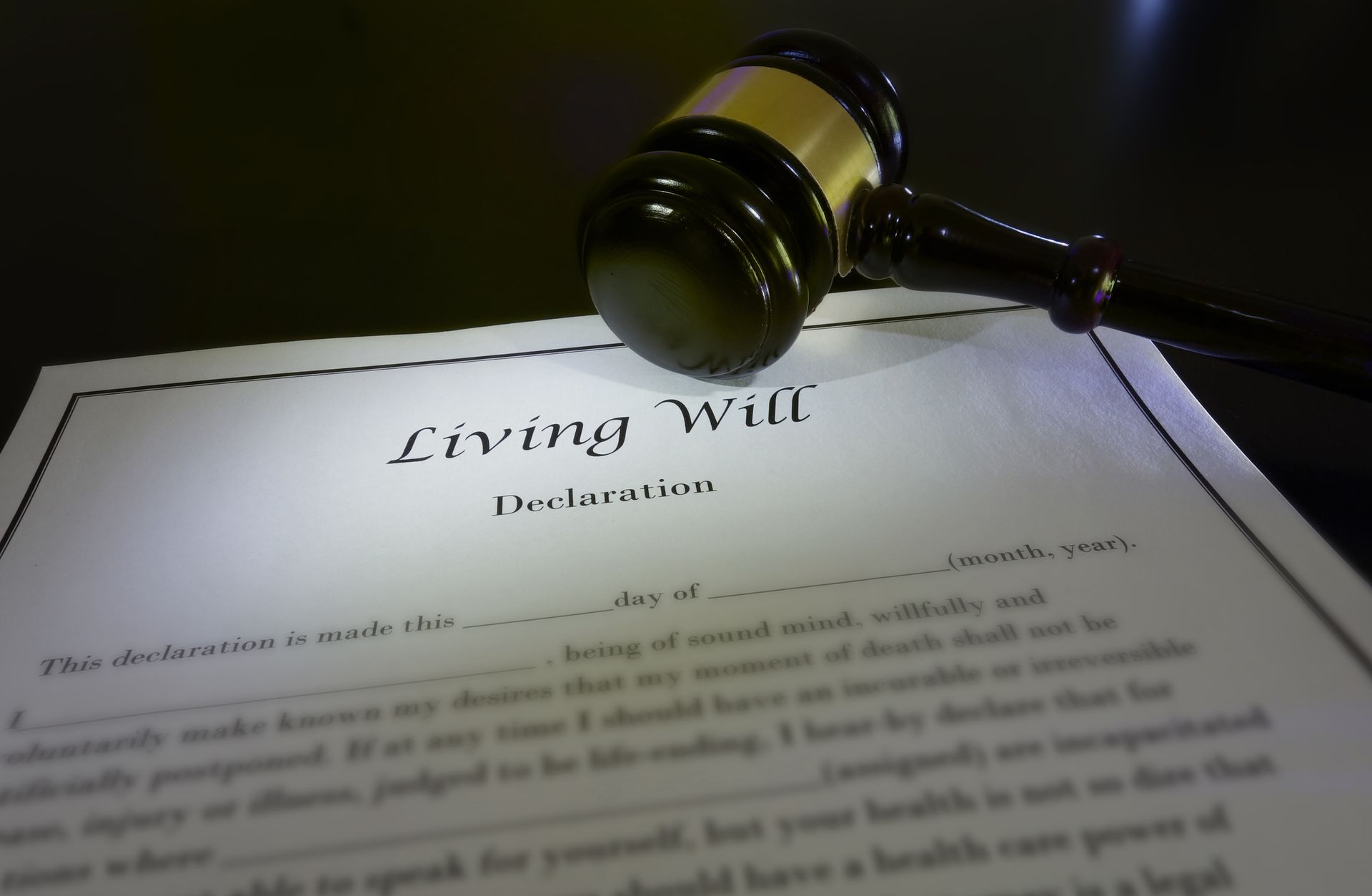 Wooden gavel being on top of a document that reads “Living Will Declaration. 