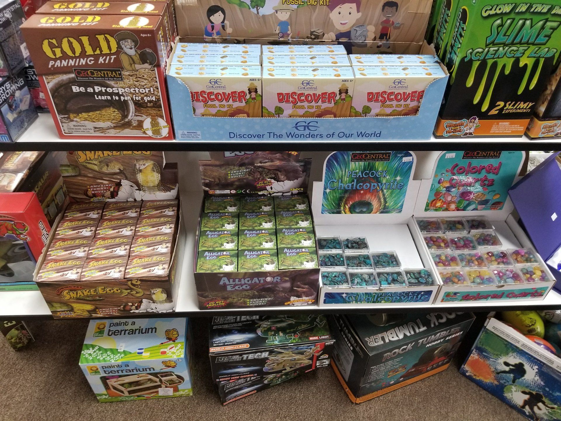 A shelf filled with lots of boxes of toys including one that says gold