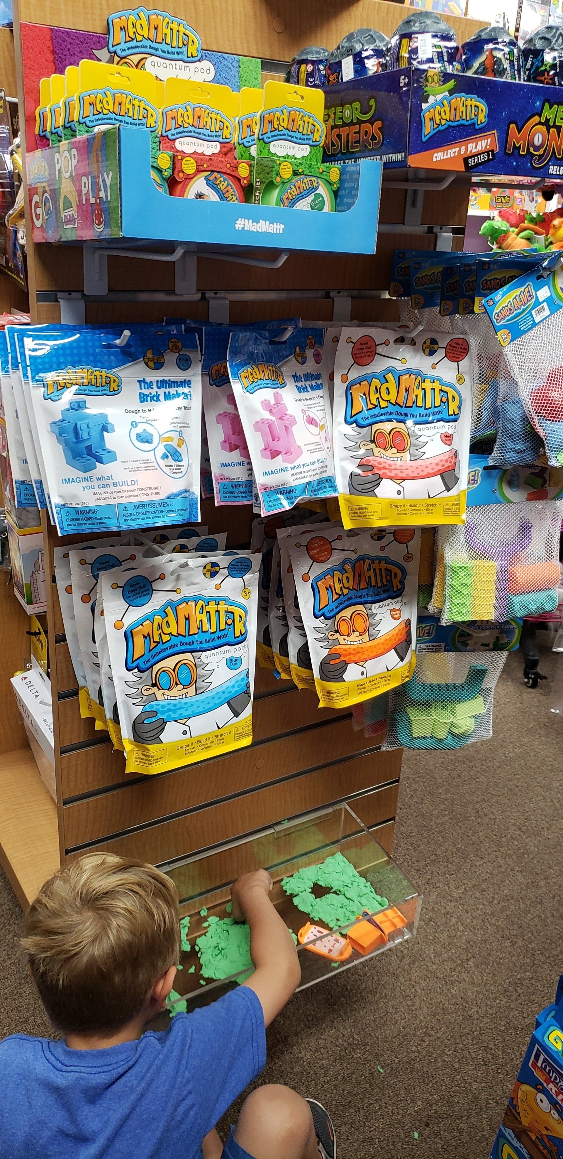 A young boy is playing with toys in a store.