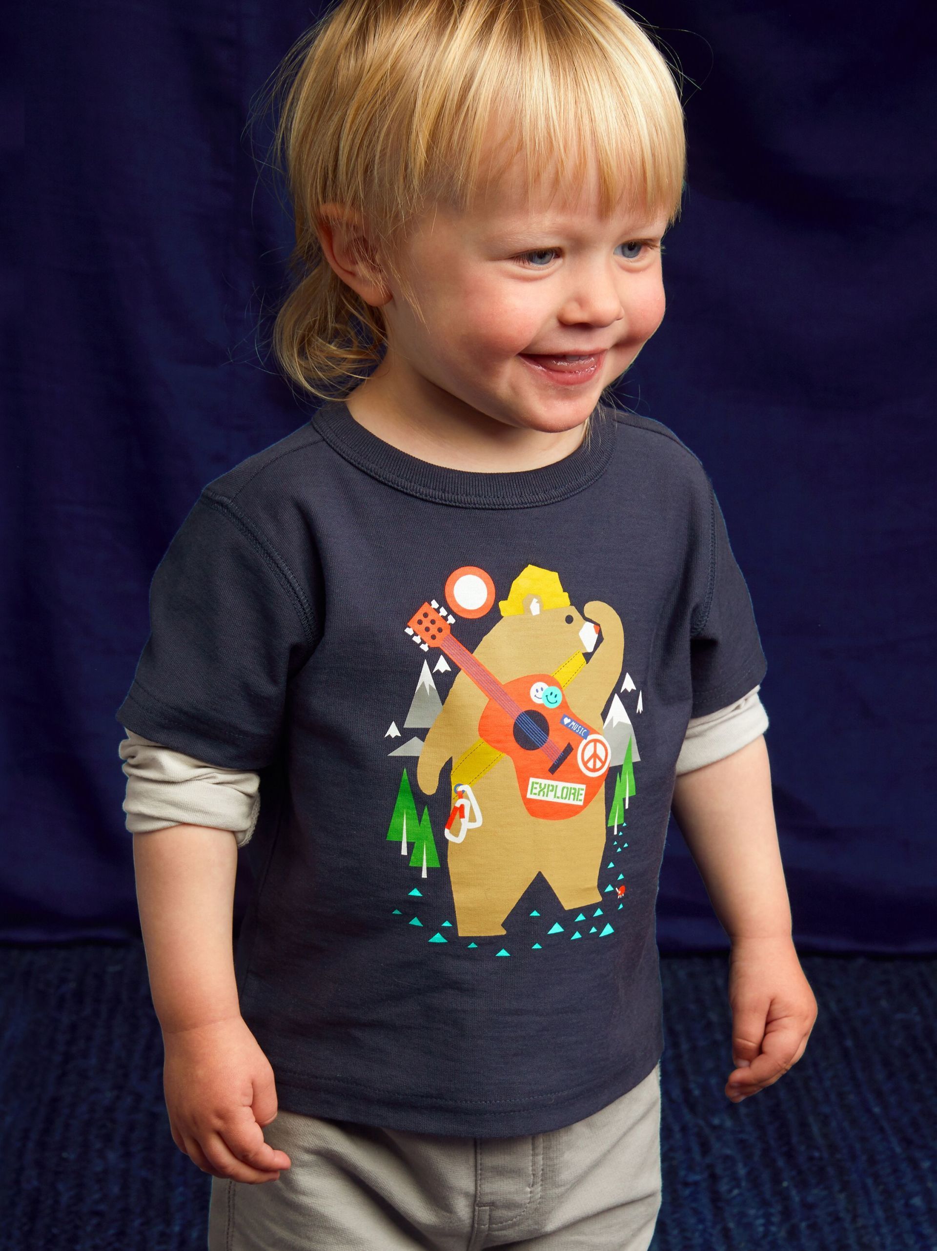 A little boy wearing a t-shirt with a bear on it