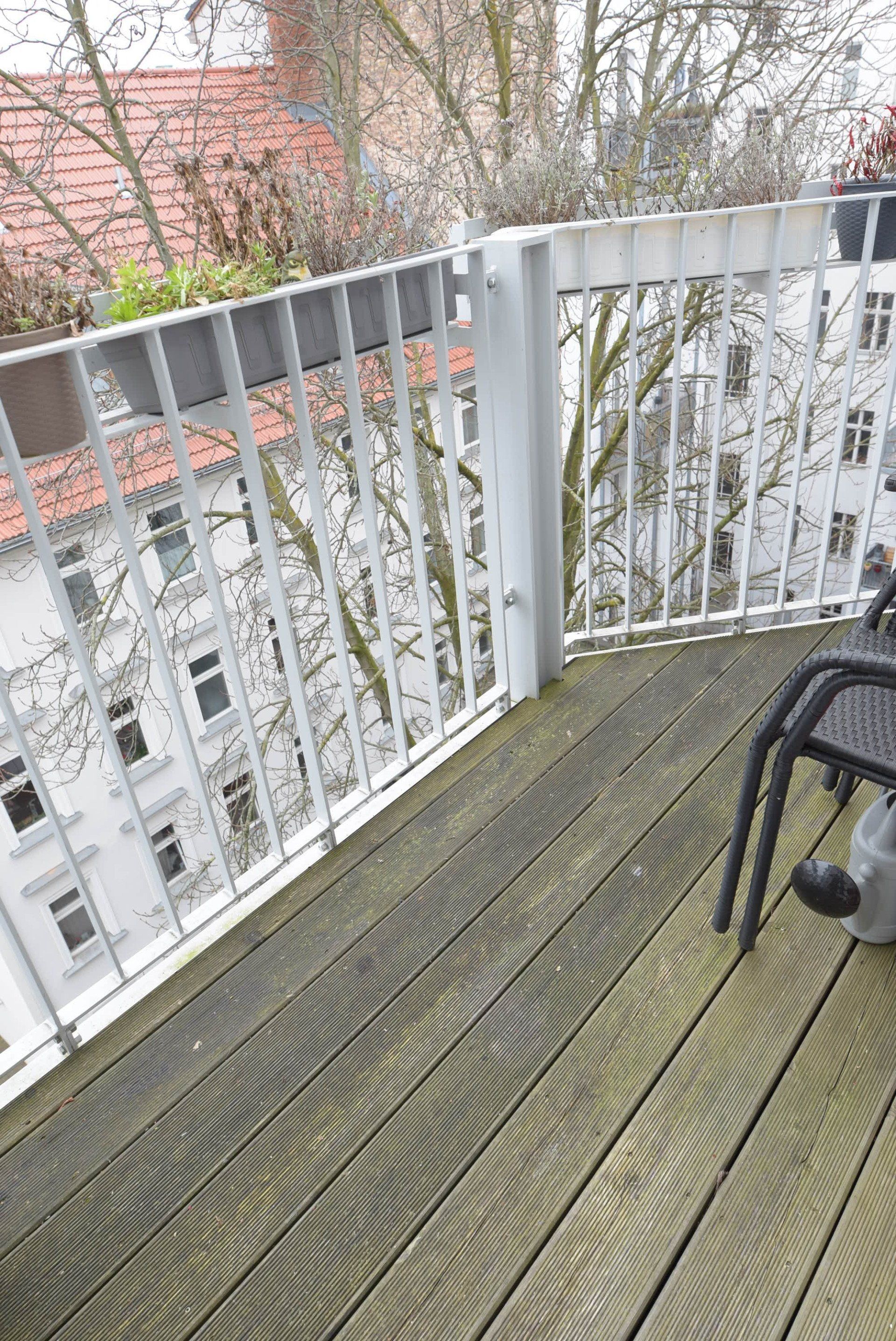 Auf dem Balkon steht ein Stuhl mit Blick auf die Stadt.
