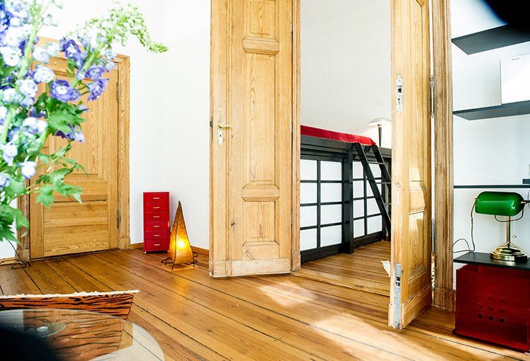 Ein Zimmer mit Holzboden und einem Bett in der Ecke.