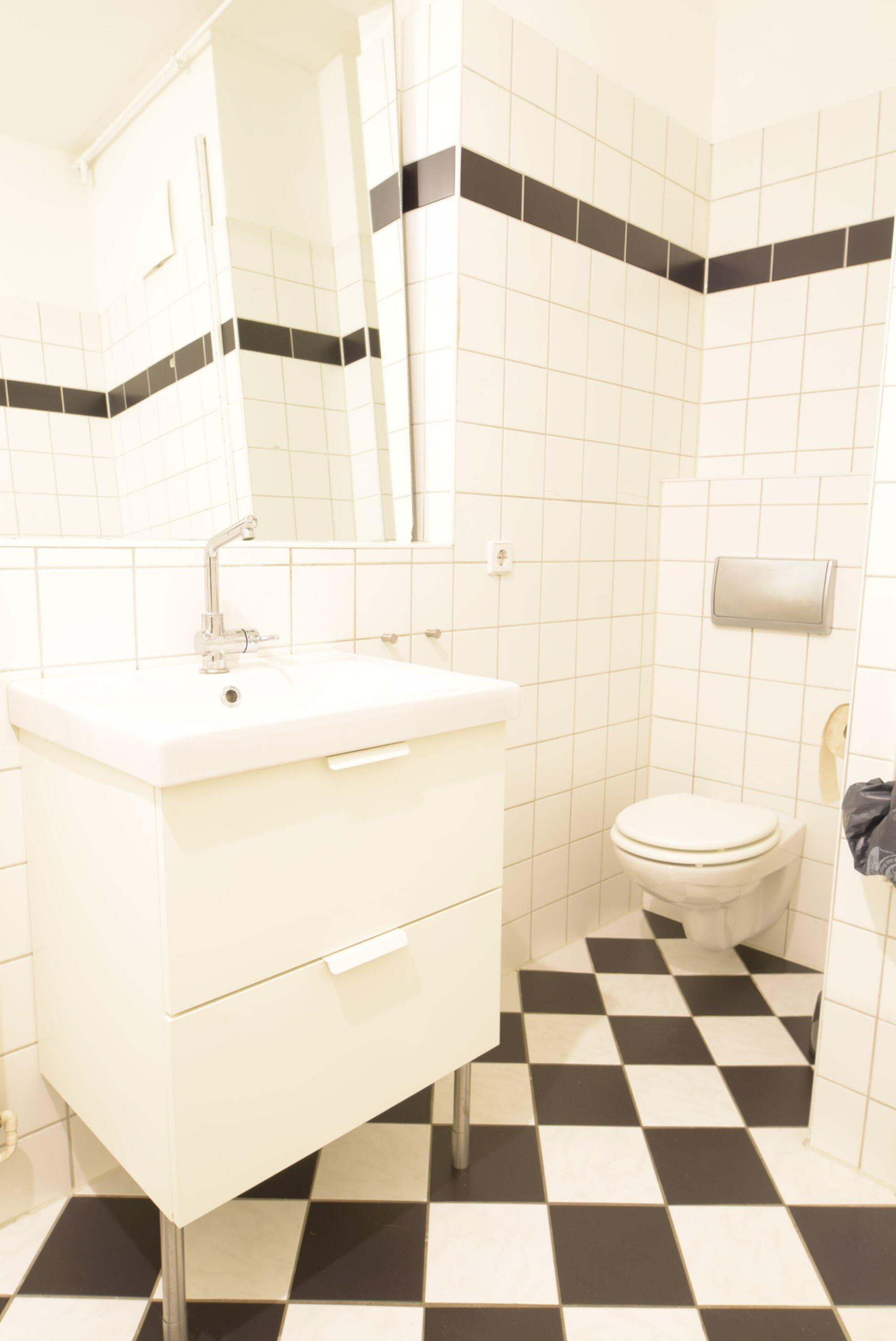 Ein Badezimmer mit einem schwarz-weiß karierten Boden