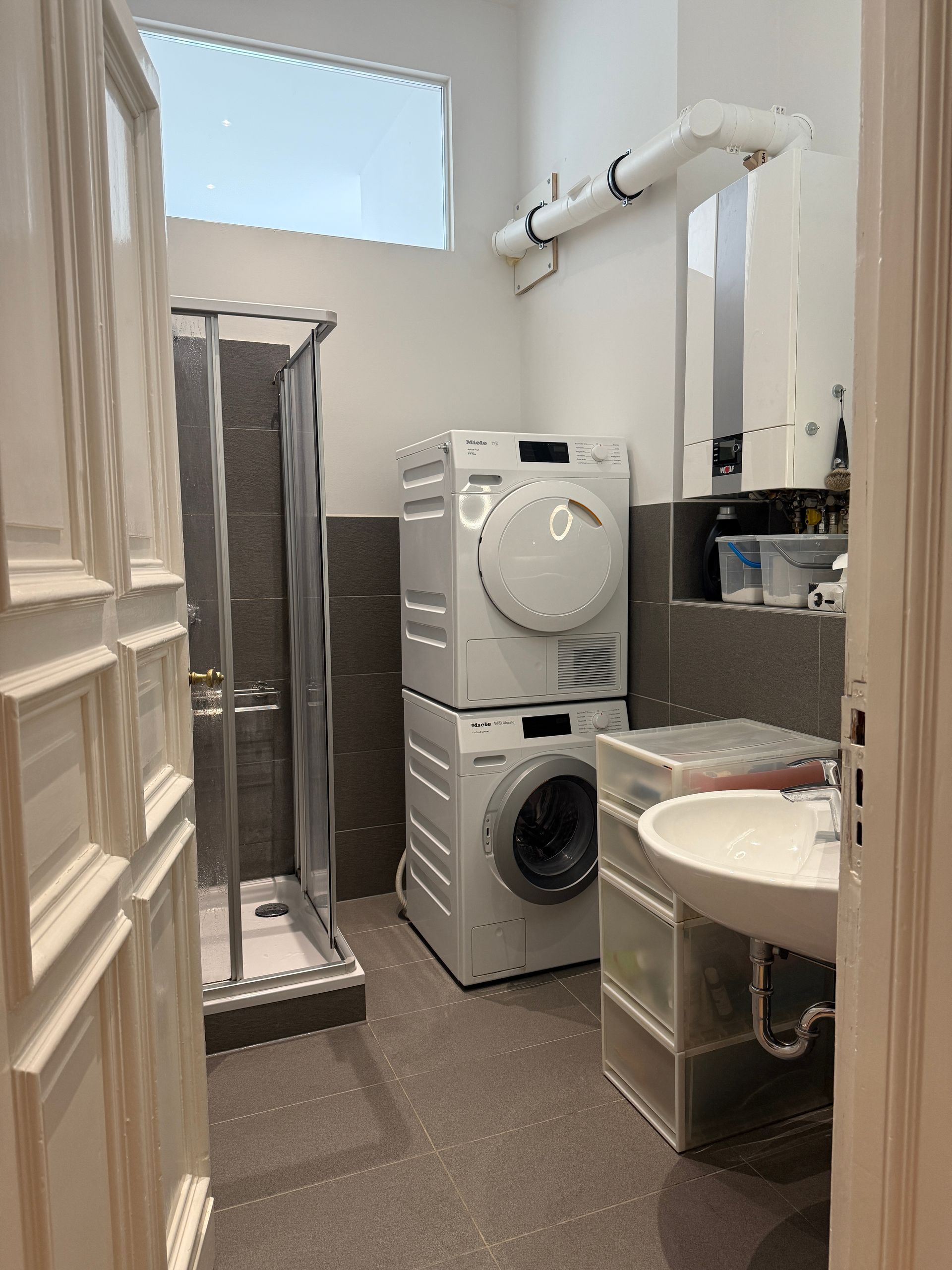 Ein Badezimmer mit übereinander gestapelter Waschmaschine und Trockner.