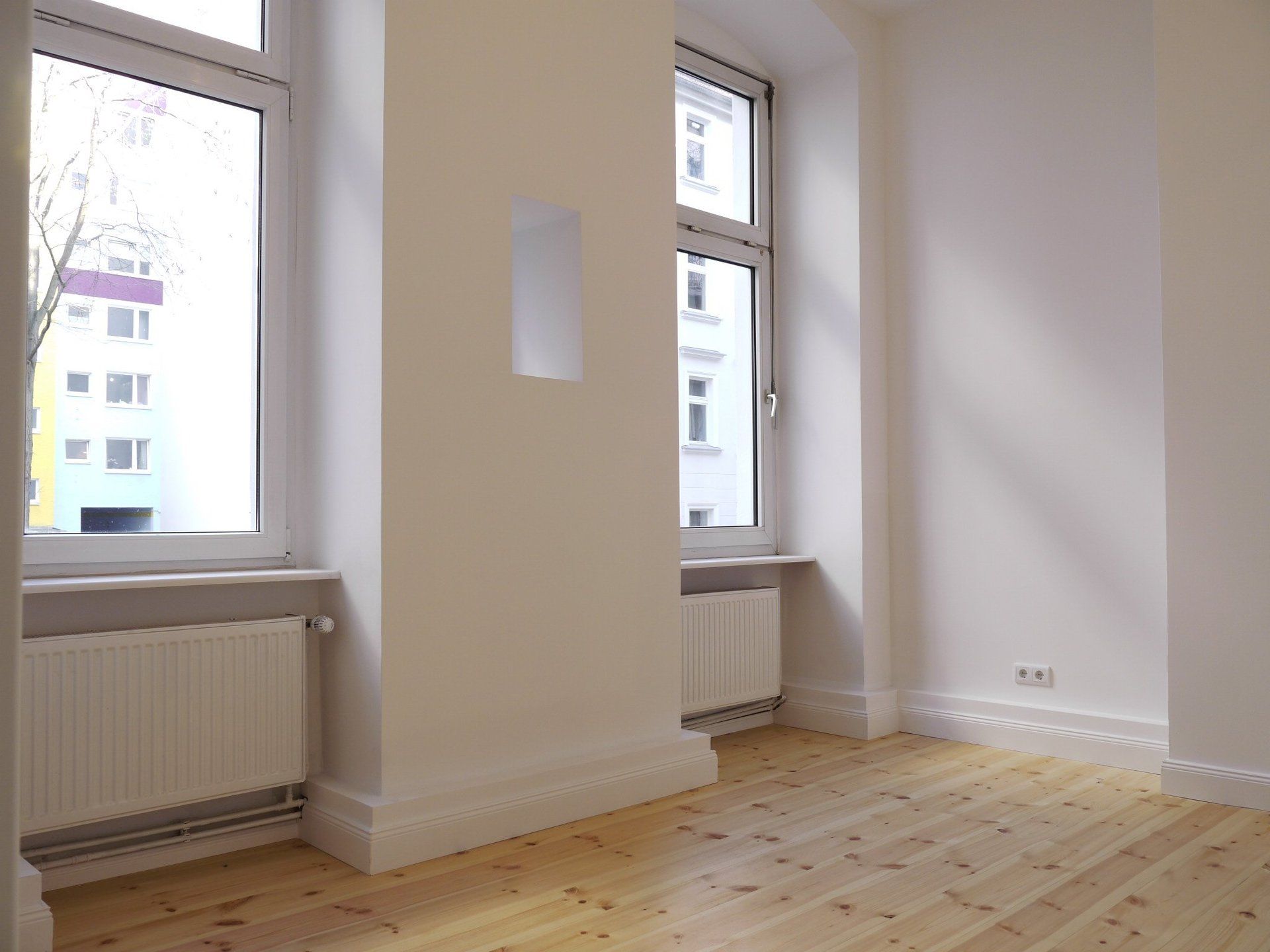 Ein leerer Raum mit Holzboden und Fenster