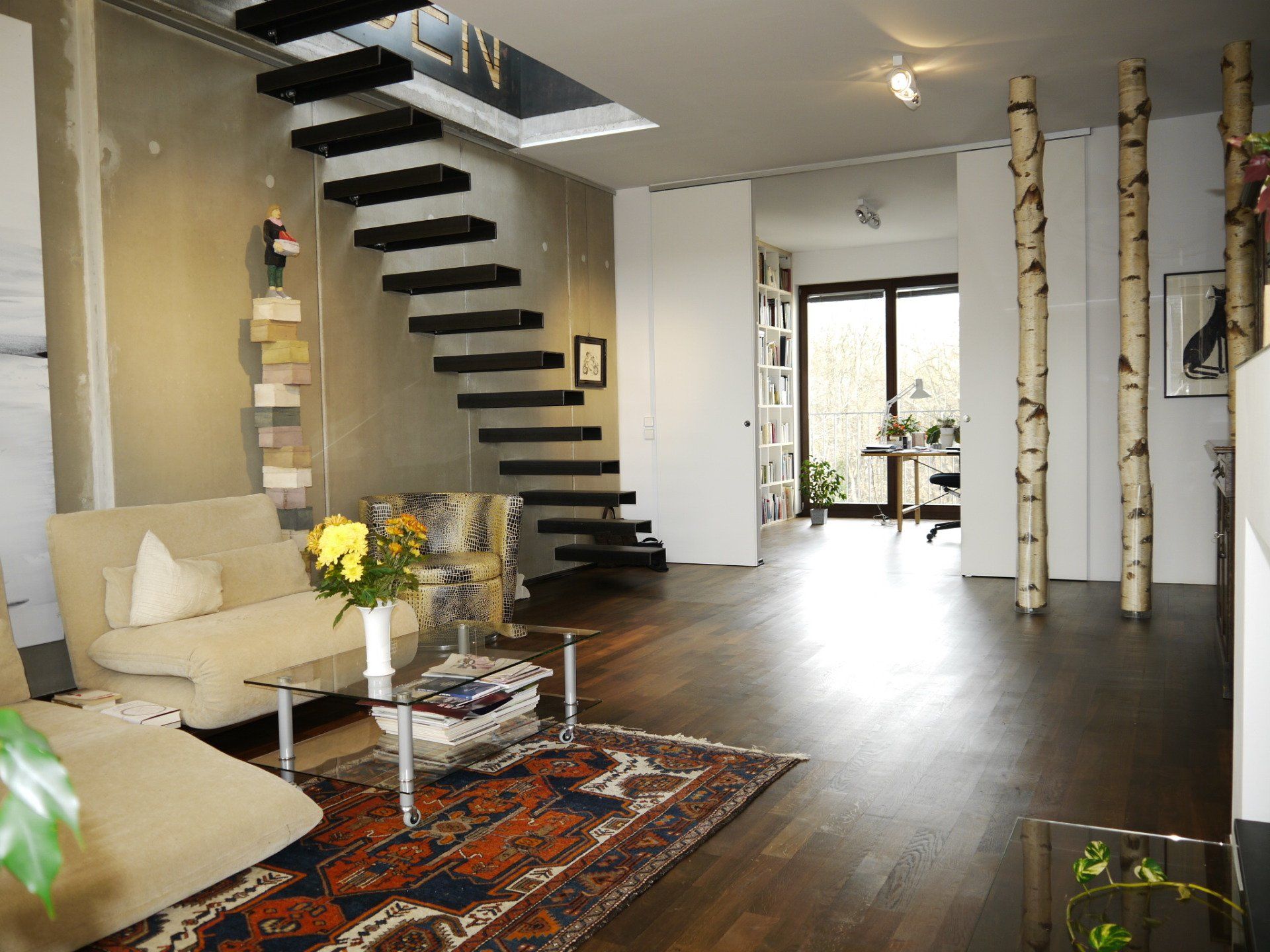 Ein Wohnzimmer mit einer Treppe, die in den zweiten Stock führt