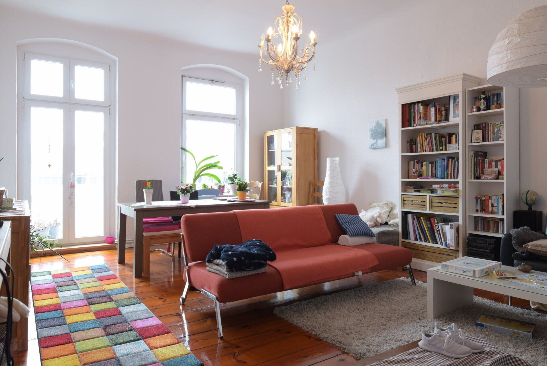 Ein Wohnzimmer mit einem roten Sofa und einem Kronleuchter.