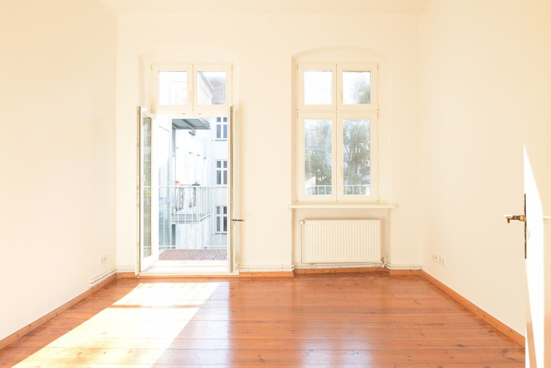 Ein leeres Wohnzimmer mit Hartholzböden und weißen Wänden.