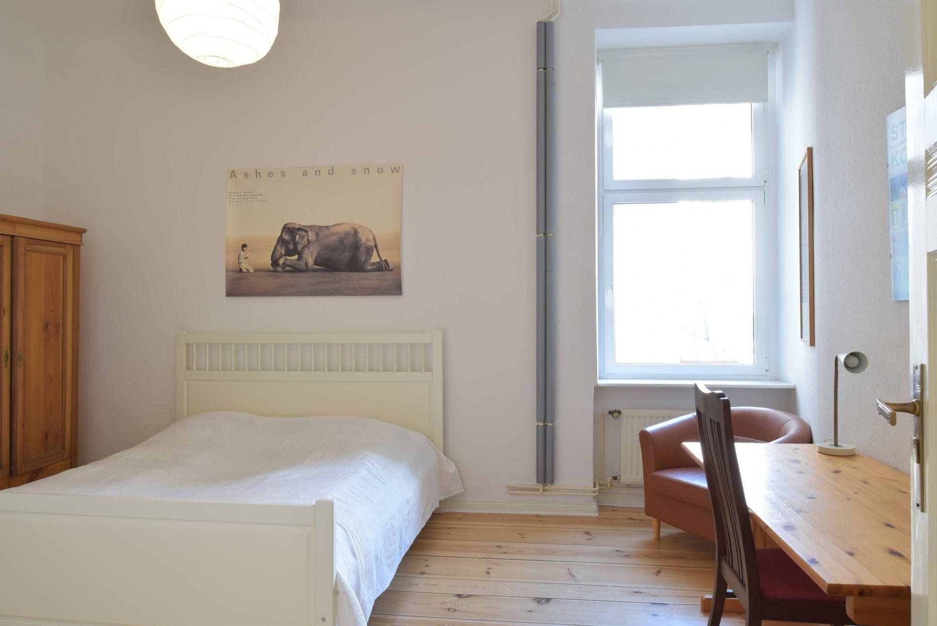 An der Wand über dem Bett hängt ein Bild von einem Elefanten.