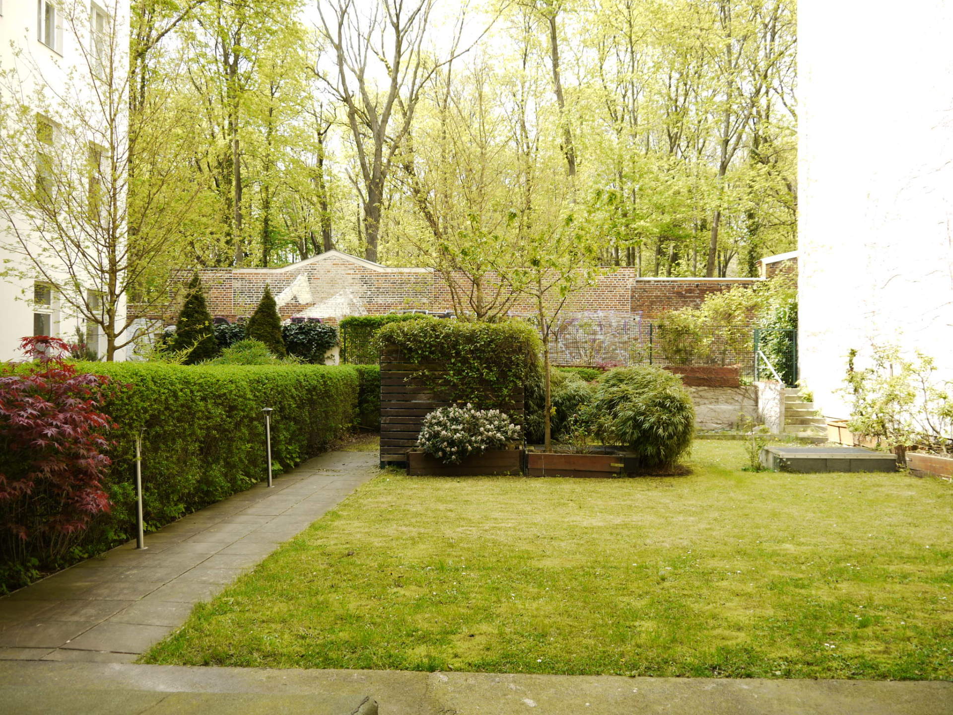 Ein Hinterhof mit einem üppigen grünen Rasen und Bäumen im Hintergrund