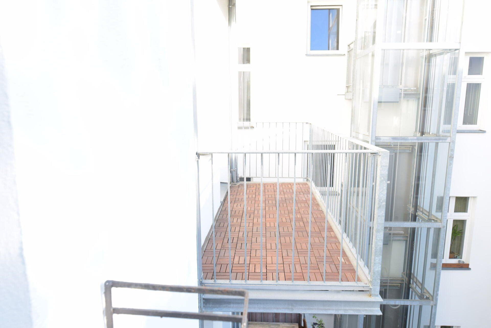 Ein Balkon mit einer Feuerleiter an der Seite eines Gebäudes.