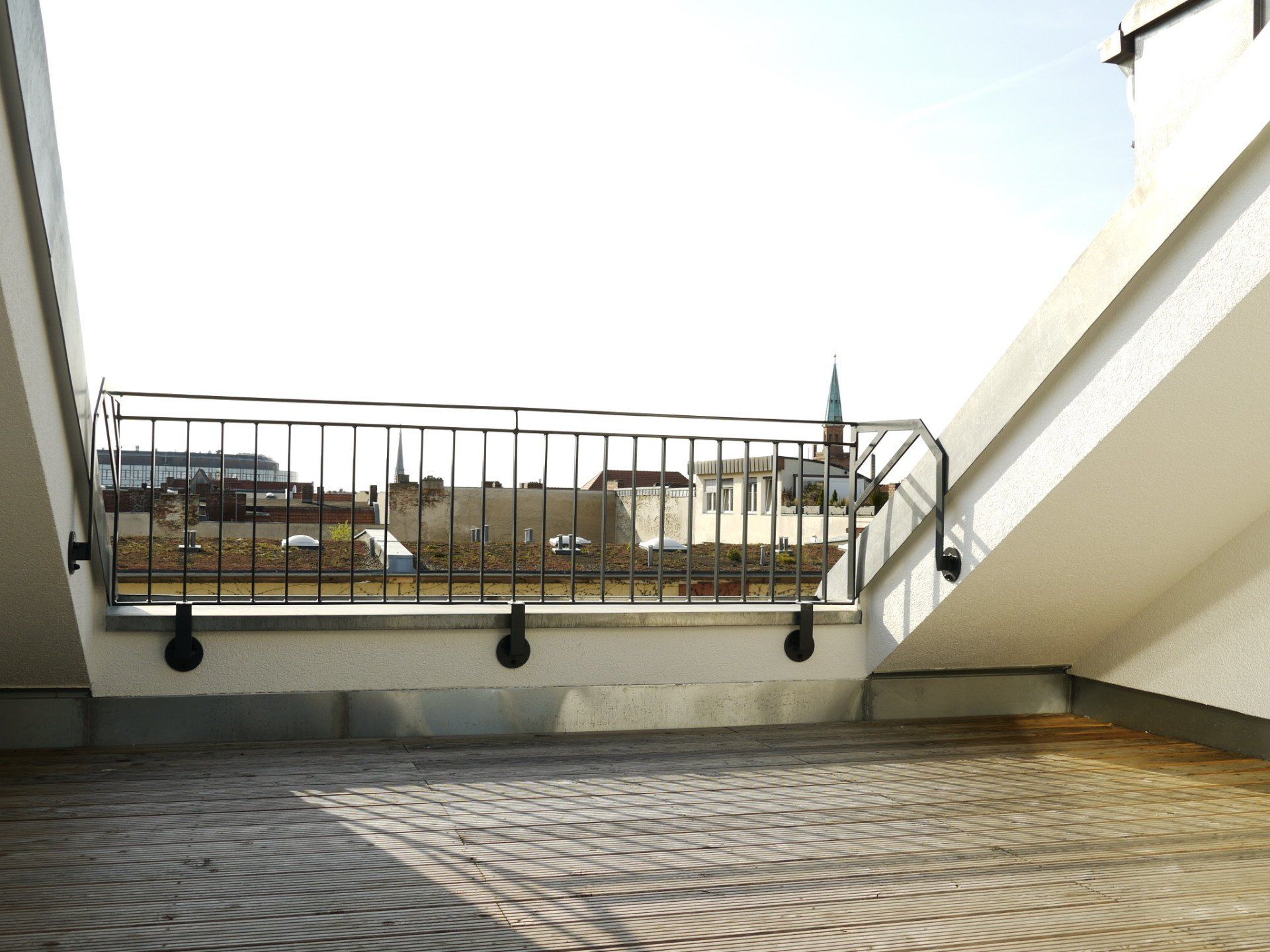 Ein Balkon mit Metallgeländer und Ziegelboden