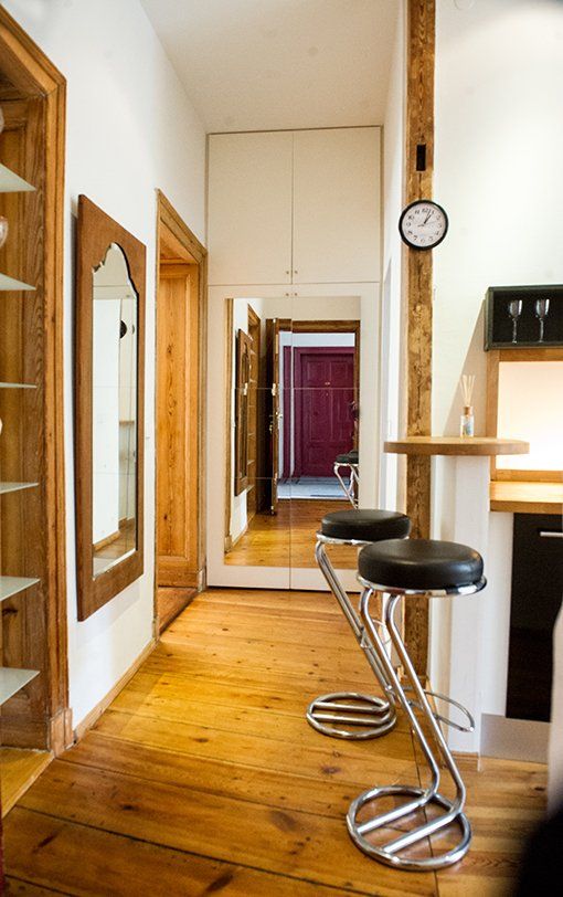 Ein Flur mit zwei Barhockern und einer Uhr an der Wand