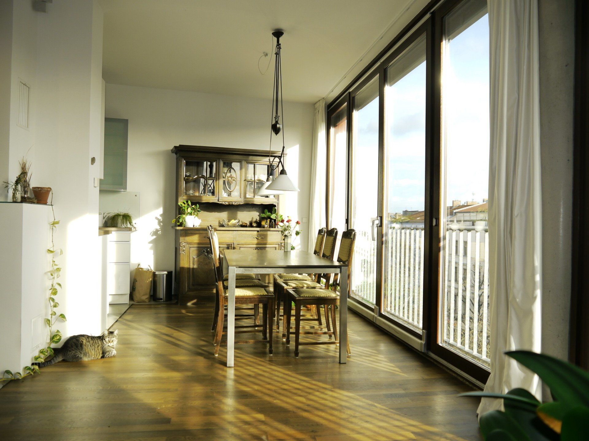 Ein Esszimmer mit Tisch und Stühlen und ein Balkon